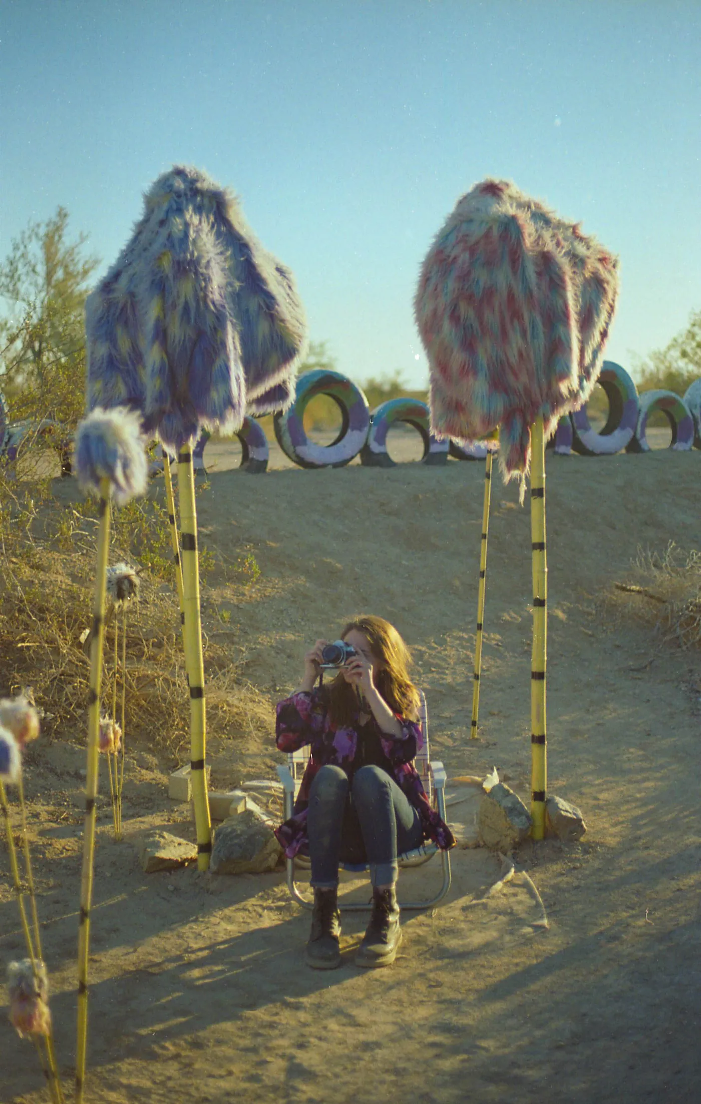 A photographer among tall handmade forms.