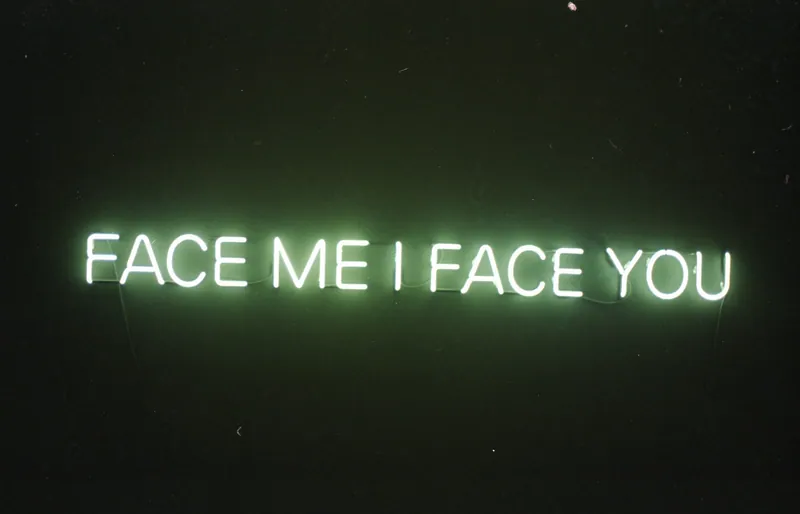 A red neon artwork glowing in a dark room